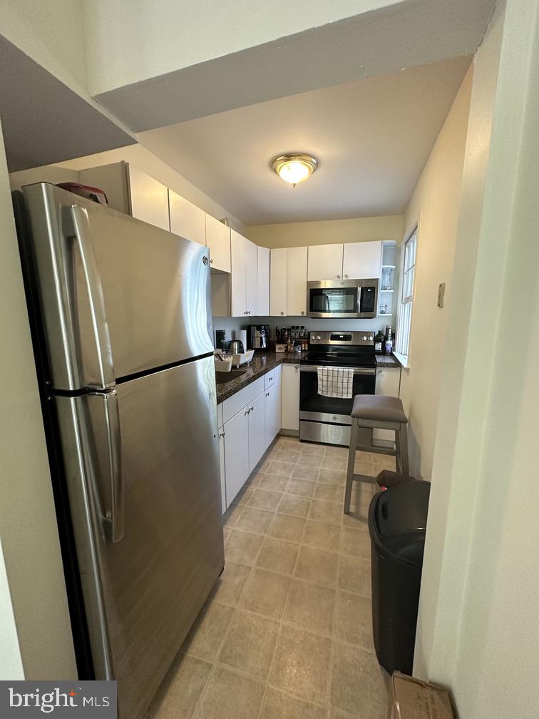29 West State Street, Unit 1 Doylestown, PA 18901 - Photo 6 of 7 a kitchen with granite countertop a refrigerator and a sink