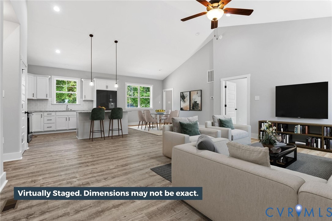 Living room with high vaulted ceiling, light wood-