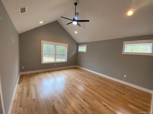 a living room with hard wood floors and a kitchen view