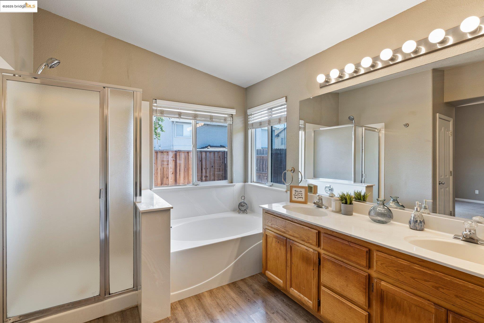 5200 Mohican Way Antioch, CA 94531 - Photo 28 of 50 a bathroom with double vanity sinks a large mirror and a bathtub