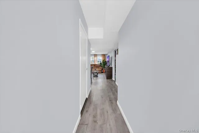 a view of a hallway with wooden floor and a living room