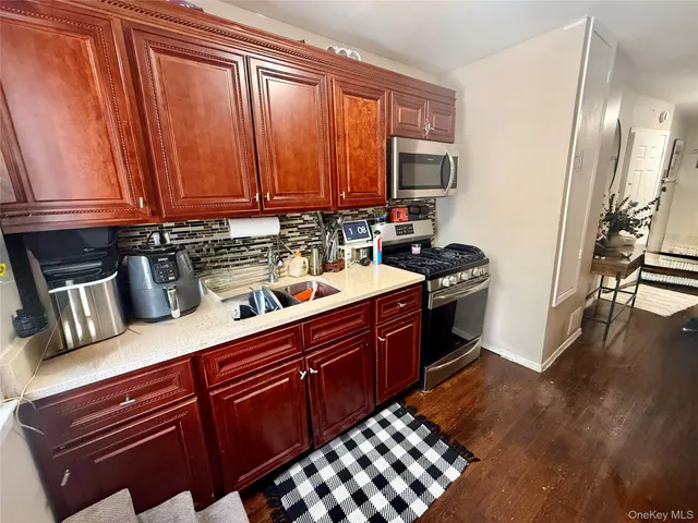 a living room with wooden floor and a mirror