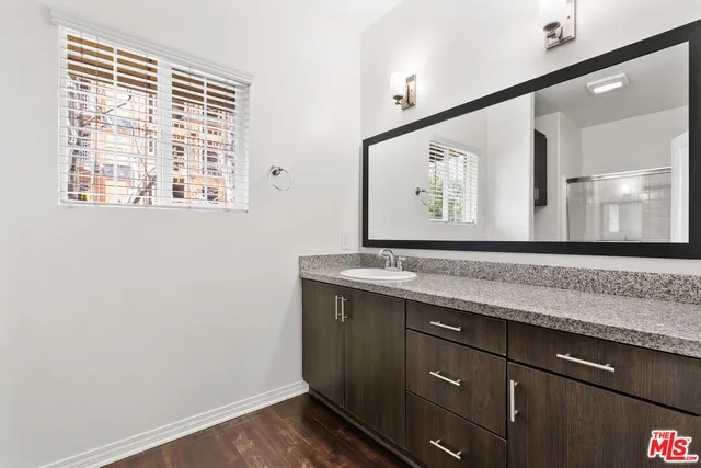 a bathroom with a granite countertop sink and a large mirror