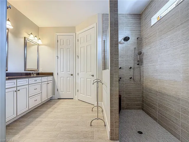 a bathroom with a granite countertop sink mirror and shower