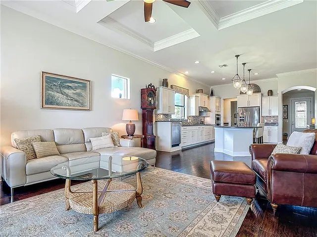 a living room with furniture and a view of kitchen