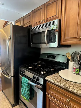 a kitchen with granite countertop a stove and a microwave