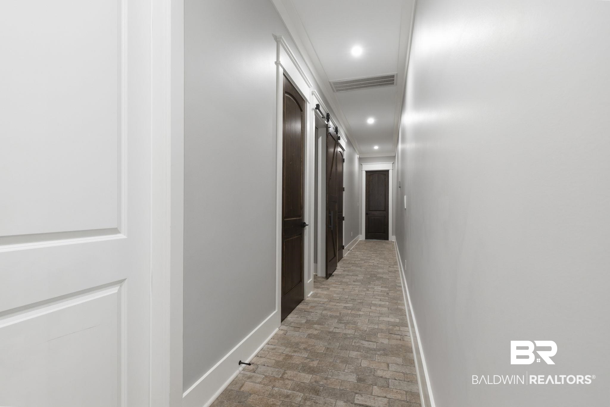 9501 Ben Hamilton Road Theodore, AL 36582 - Photo 45 of 69 Hall featuring crown molding, a barn door, recessed lighting, and brick flooring