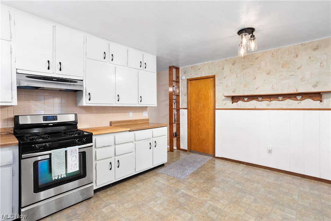 387 Fairfax Road Vermilion, OH 44089 - Photo 14 of 35 Kitchen with white cabinetry, stainless steel gas range, backsplash, and light tile floors