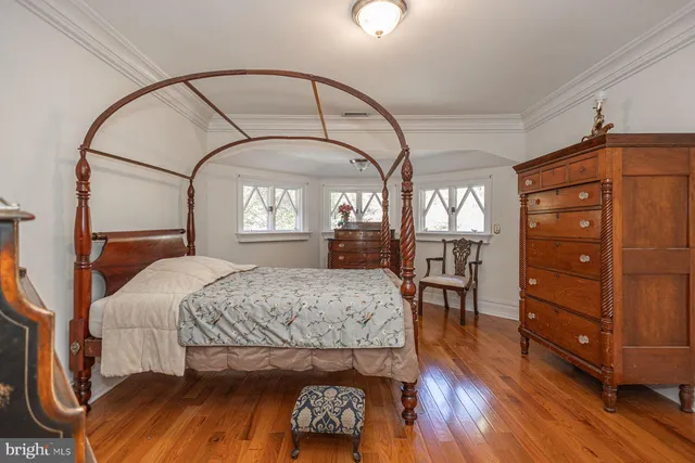 a bedroom with a large bed and wooden floor