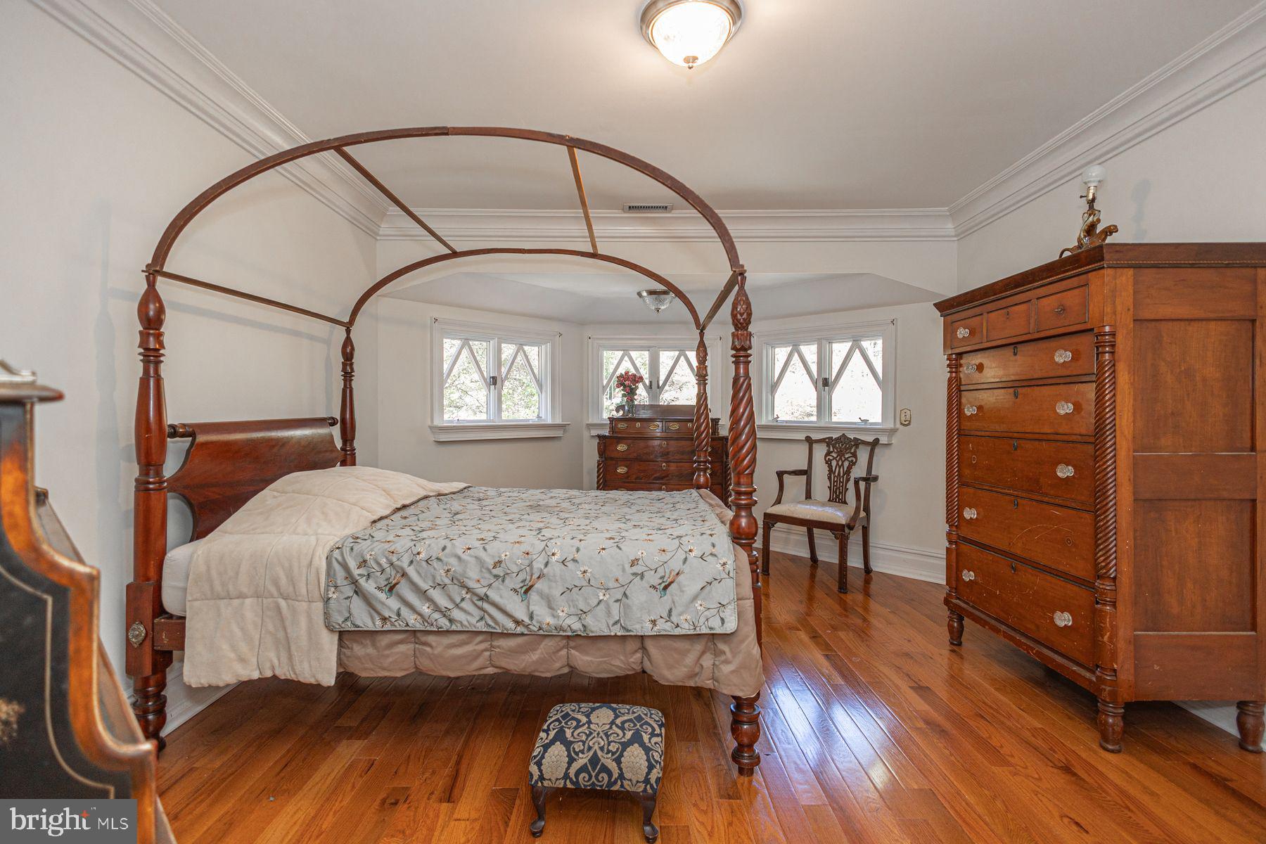 132 East Dark Hollow Road, Unit MAIN Pipersville, PA 18947 - Photo 15 of 29 a bedroom with a large bed and wooden floor