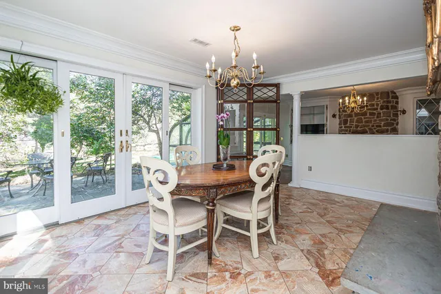 a dining room with furniture a chandelier and window