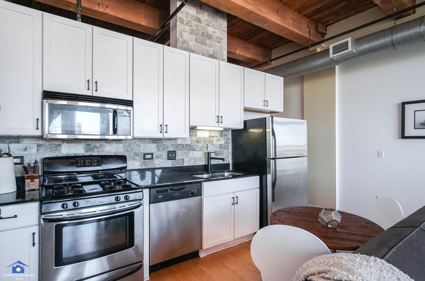1503 South State Street, Unit 602 Chicago, IL 60605 - Photo 6 of 21 a kitchen with stainless steel appliances granite countertop a refrigerator stove and white cabinets