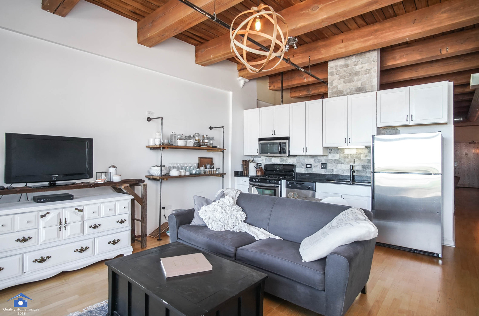 1503 South State Street, Unit 602 Chicago, IL 60605 - Photo 9 of 21 a kitchen with stainless steel appliances granite countertop a refrigerator a stove a sink dishwasher a dining table and chairs with wooden floor
