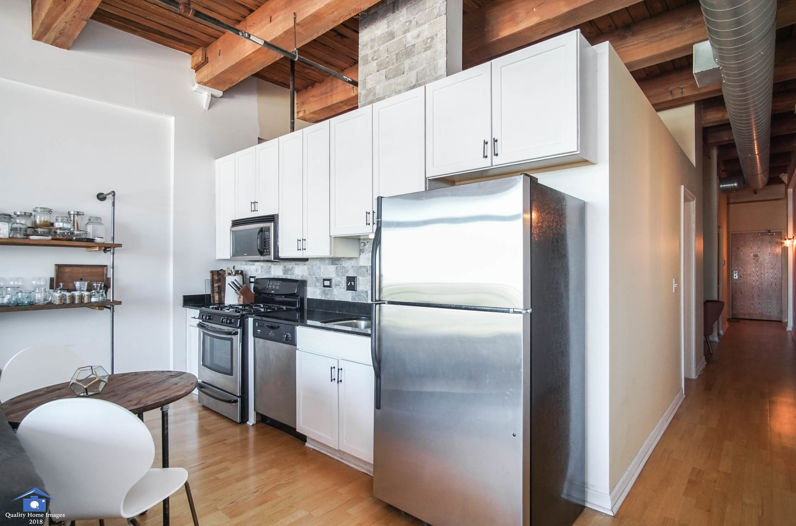 1503 South State Street, Unit 602 Chicago, IL 60605 - Photo 10 of 21 a kitchen with stainless steel appliances granite countertop a refrigerator a stove a sink and white cabinets with wooden floor