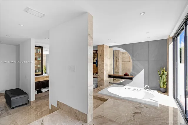 a bathroom with a tub sink and mirror