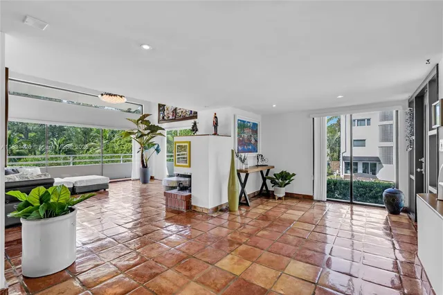 a living room with patio furniture and a floor to ceiling window