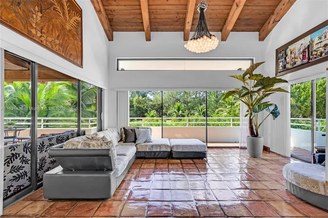 a living room with patio furniture and a large window