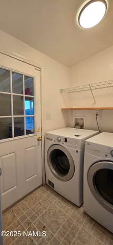 an empty room with a chandelier fan and windows