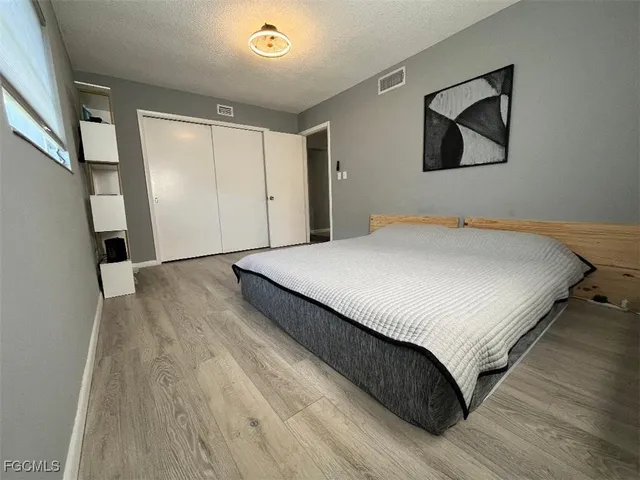 a bedroom with a bed and a painting on the wall