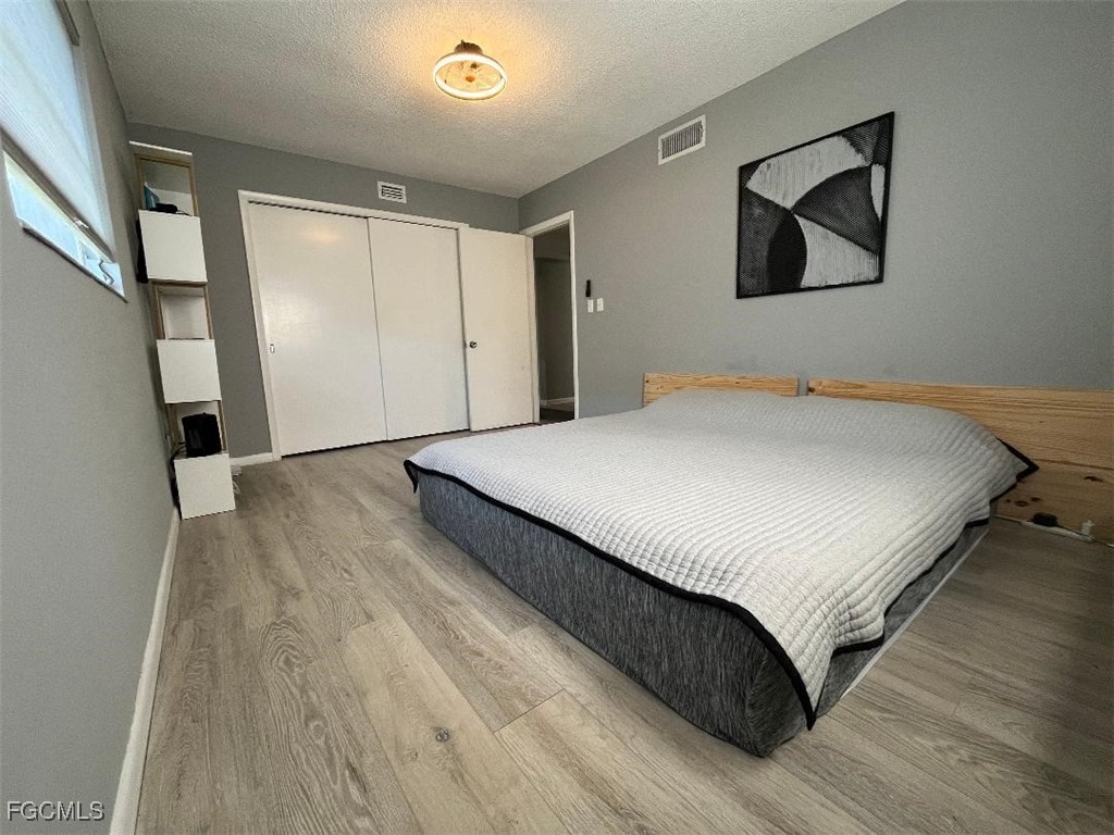 2210 Croton Court Lehigh Acres, FL 33936 - Photo 8 of 13 a bedroom with a bed and a painting on the wall