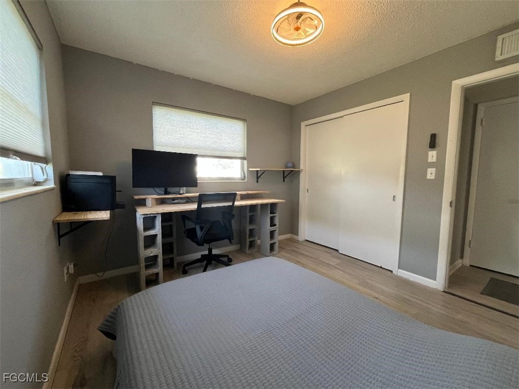 2210 Croton Court Lehigh Acres, FL 33936 - Photo 9 of 13 a bedroom with a bed and a flat screen tv