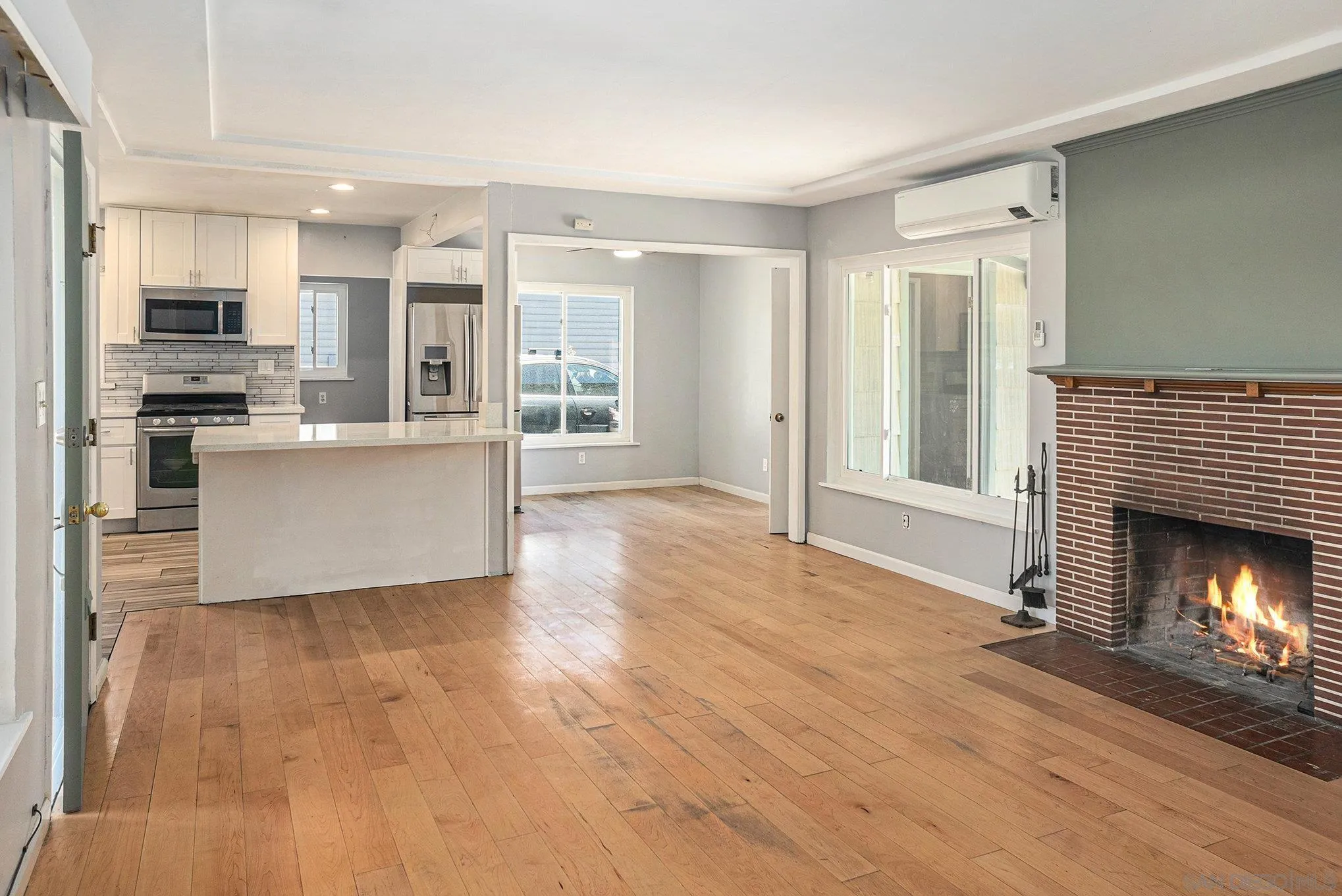 74 E Street Chula Vista, CA 91910 - Photo 35 of 56 a view of a living room a kitchen with wooden floor and a fireplace