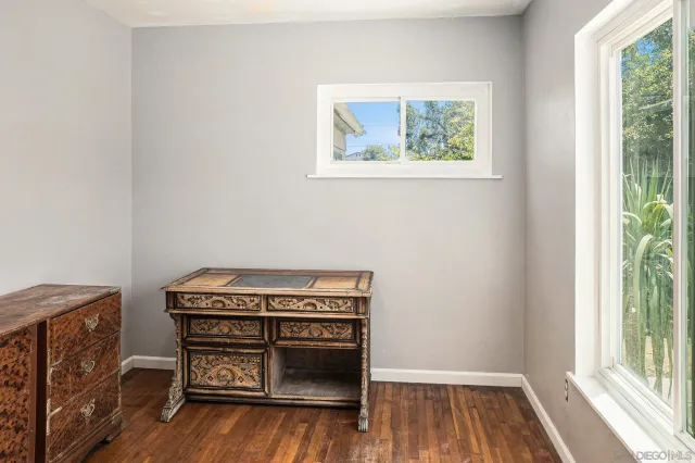 a bedroom with wooden floor and a bathroom