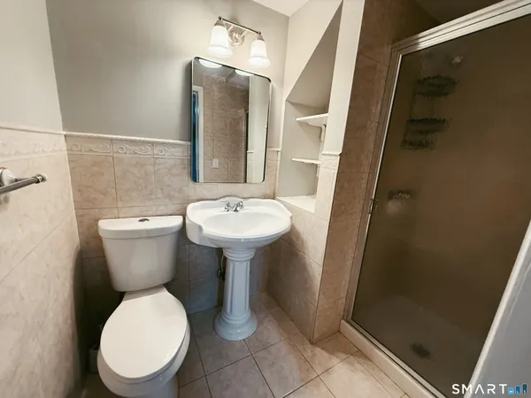 a white toilet sitting next to a bathroom sink