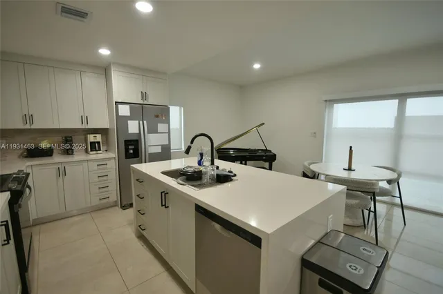 a kitchen with a sink a stove a refrigerator and white cabinets