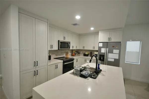 a kitchen with a sink a stove and chairs