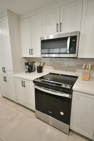 a kitchen with stainless steel appliances granite countertop a stove and a microwave
