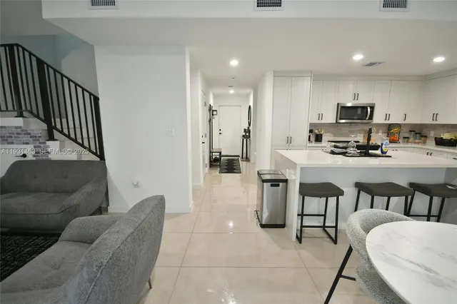 a living room with furniture and a dining table with kitchen view