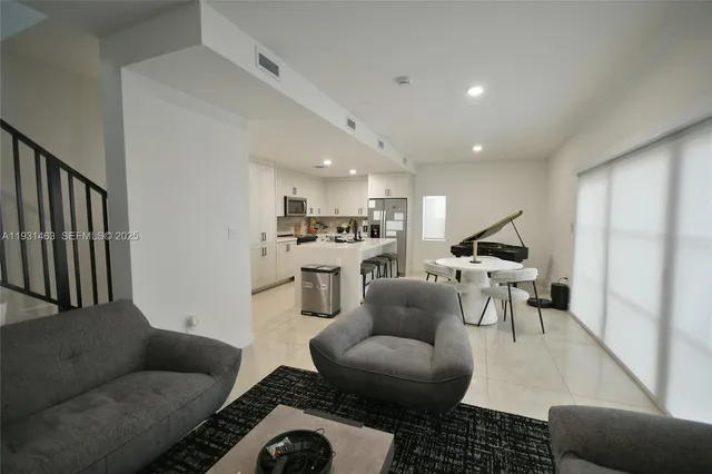 a living room with furniture and a view of kitchen