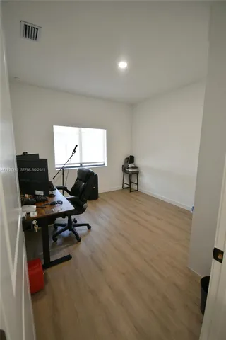 a view of a workspace with furniture and a window