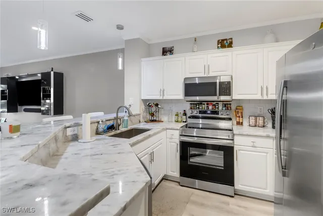 a kitchen with stainless steel appliances granite countertop a stove a sink and a refrigerator
