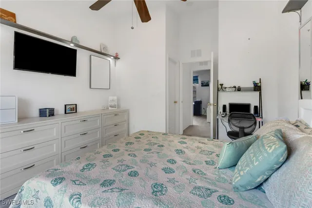 a bedroom with a bed a flat screen tv and dresser