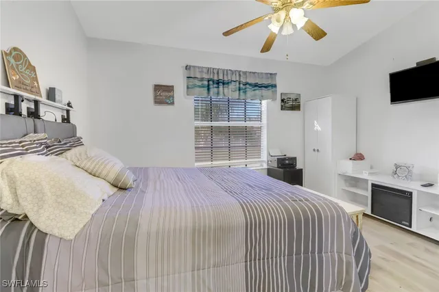 a bedroom with a bed and a flat tv screen on dresser