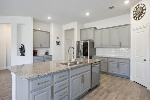 a kitchen with stainless steel appliances granite countertop a sink stove and refrigerator