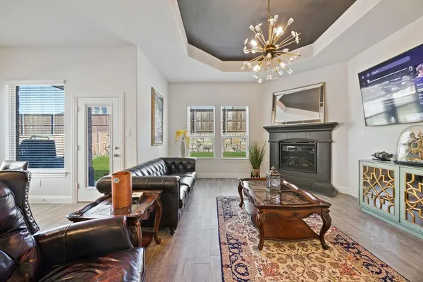 a living room with furniture chandelier and a fireplace