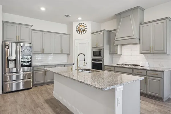 a kitchen with stainless steel appliances granite countertop a sink stove and refrigerator