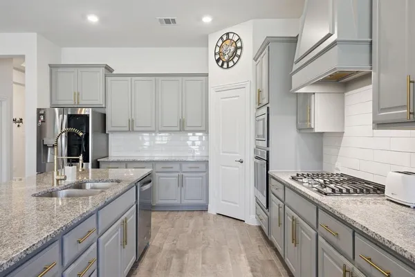 a kitchen with stainless steel appliances granite countertop a sink stove and refrigerator