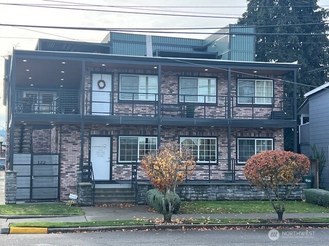 118 4th Avenue Southeast, Unit 118 Puyallup, WA 98372 - Photo 1 of 14 a front view of a house with a yard