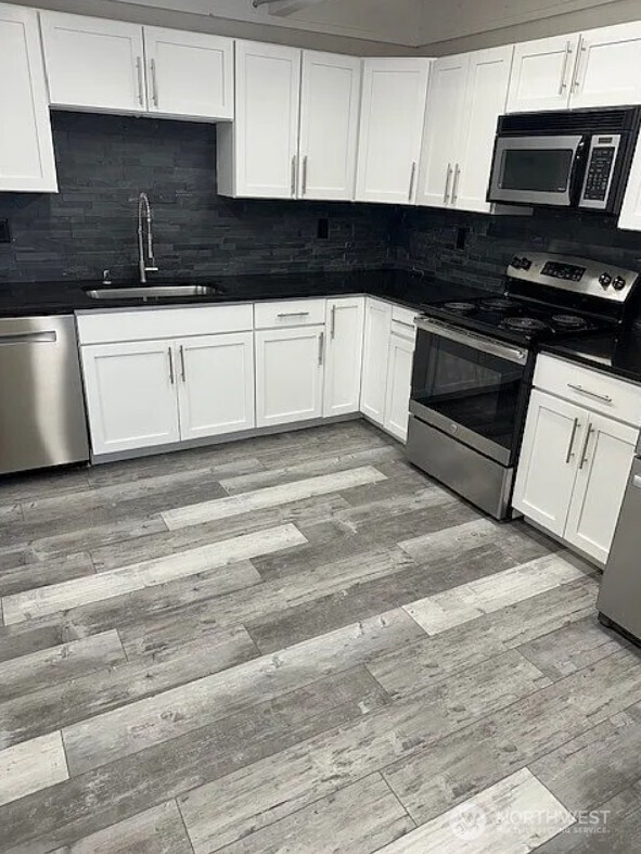 118 4th Avenue Southeast, Unit 118 Puyallup, WA 98372 - Photo 10 of 14 a kitchen with granite countertop a stove top oven a sink dishwasher and cabinets