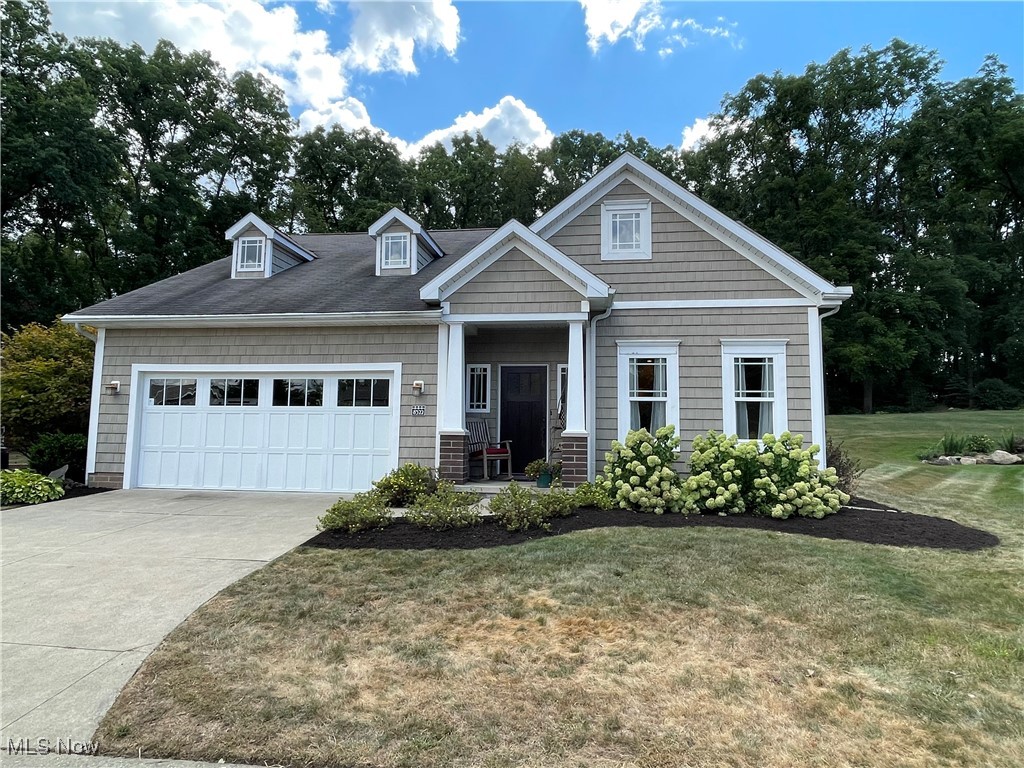 8322 Forest Ridge Street Northwest Massillon, OH 44646 - Photo 1 of 33 Craftsman-style home featuring a garage, a front lawn, driveway, and view of wooded area