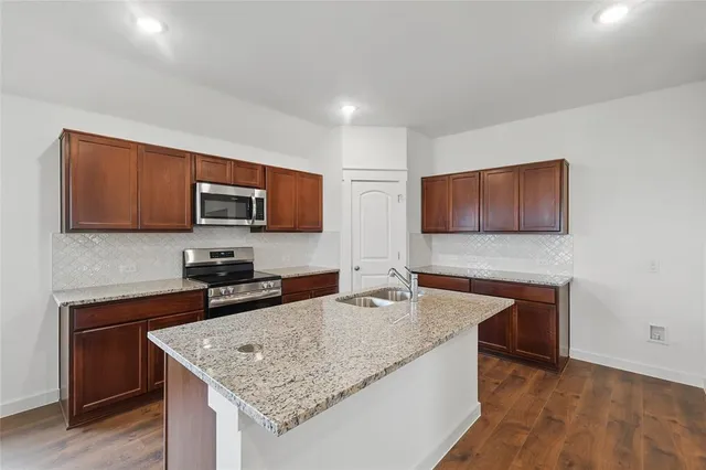a kitchen with granite countertop stainless steel appliances and wooden cabinets