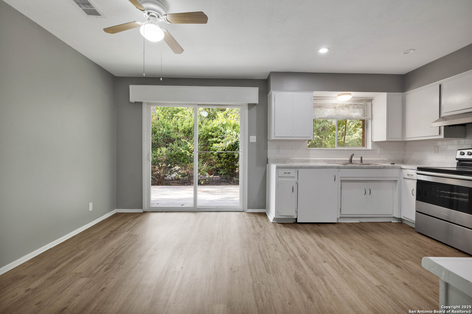 6012 Evers Road Leon Valley, TX 78238 - Photo 11 of 17 a kitchen with wooden floors and white appliances