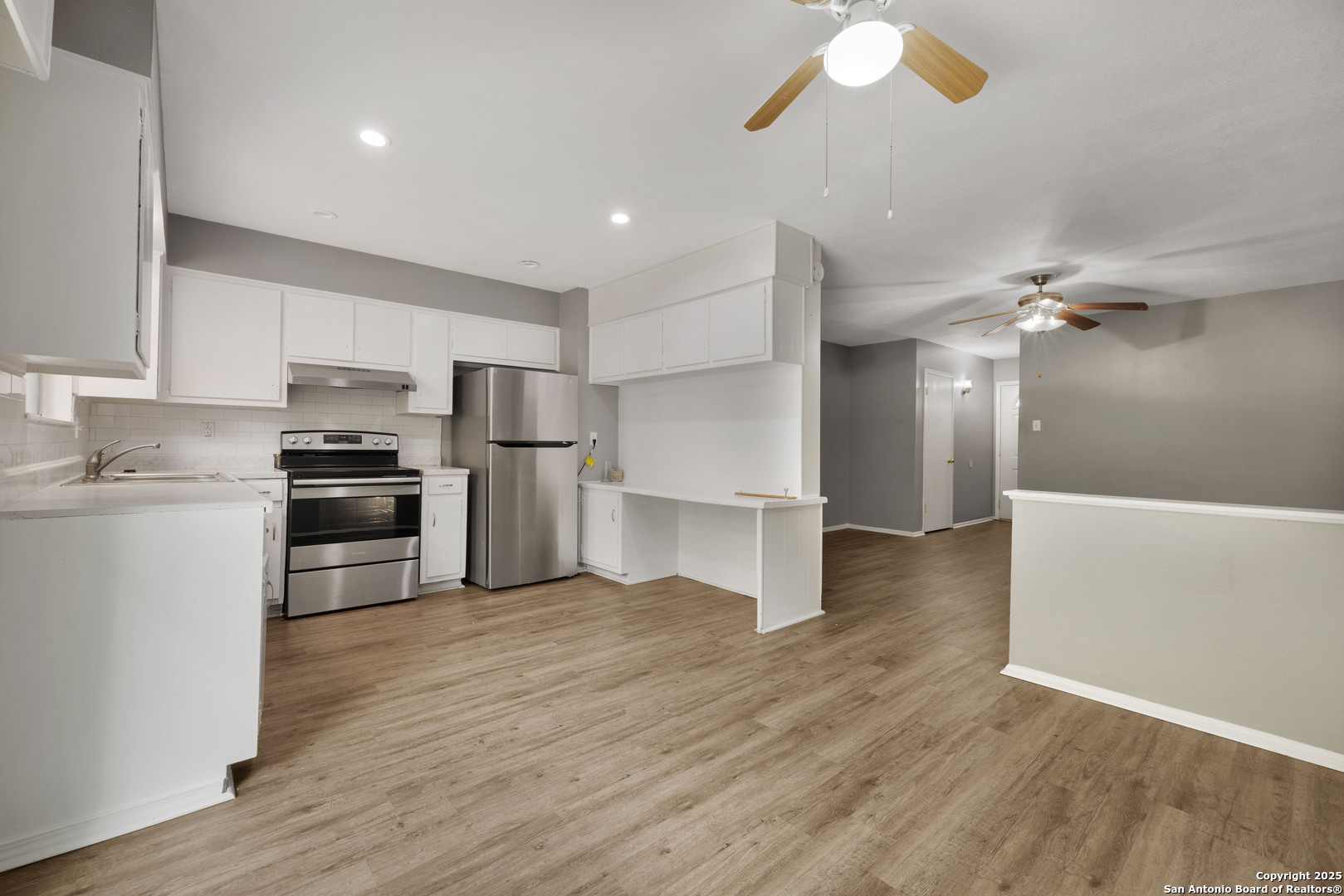 6012 Evers Road Leon Valley, TX 78238 - Photo 12 of 17 a kitchen with granite countertop a refrigerator and a stove top oven