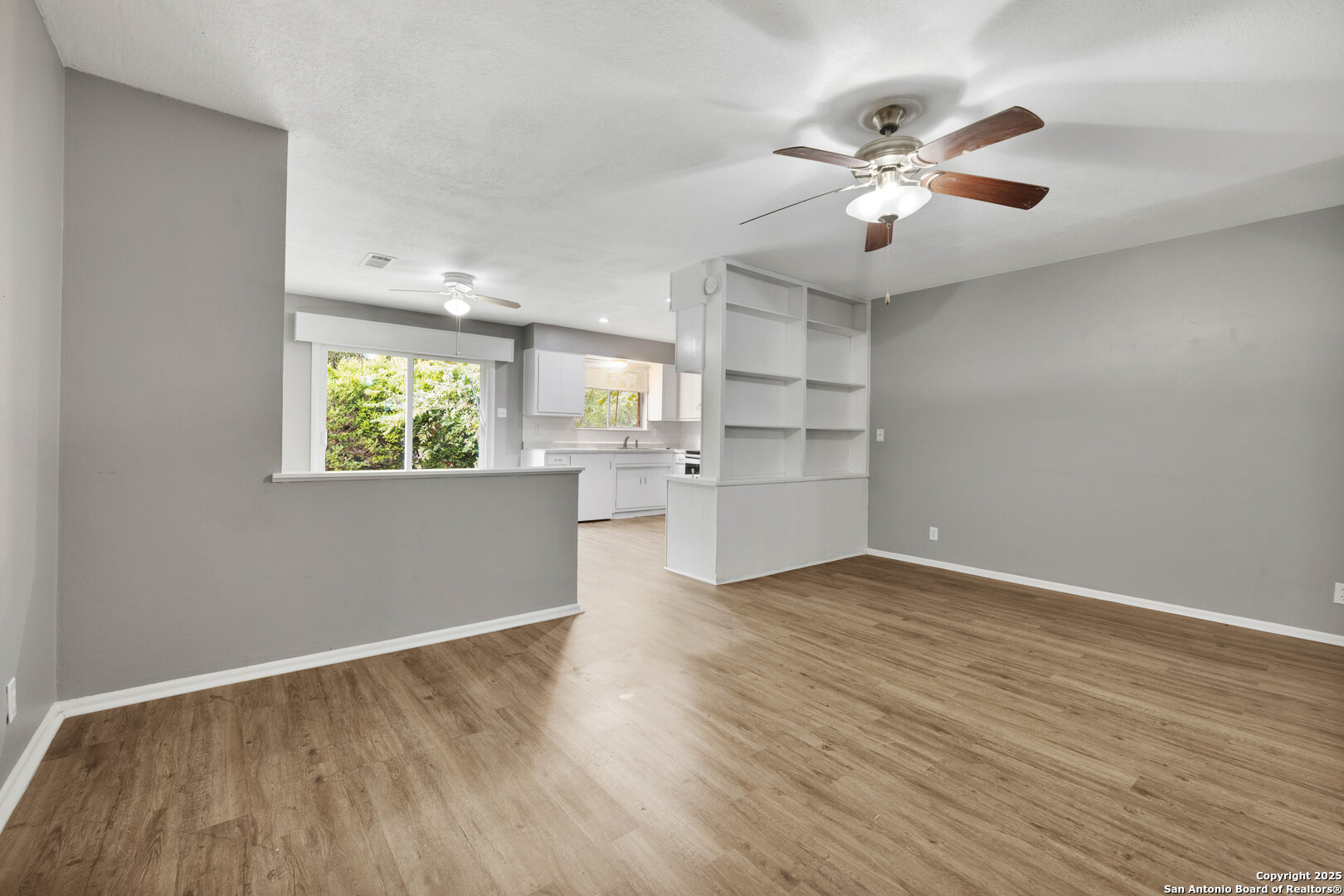 6012 Evers Road Leon Valley, TX 78238 - Photo 9 of 17 wooden floor in an empty room with a window