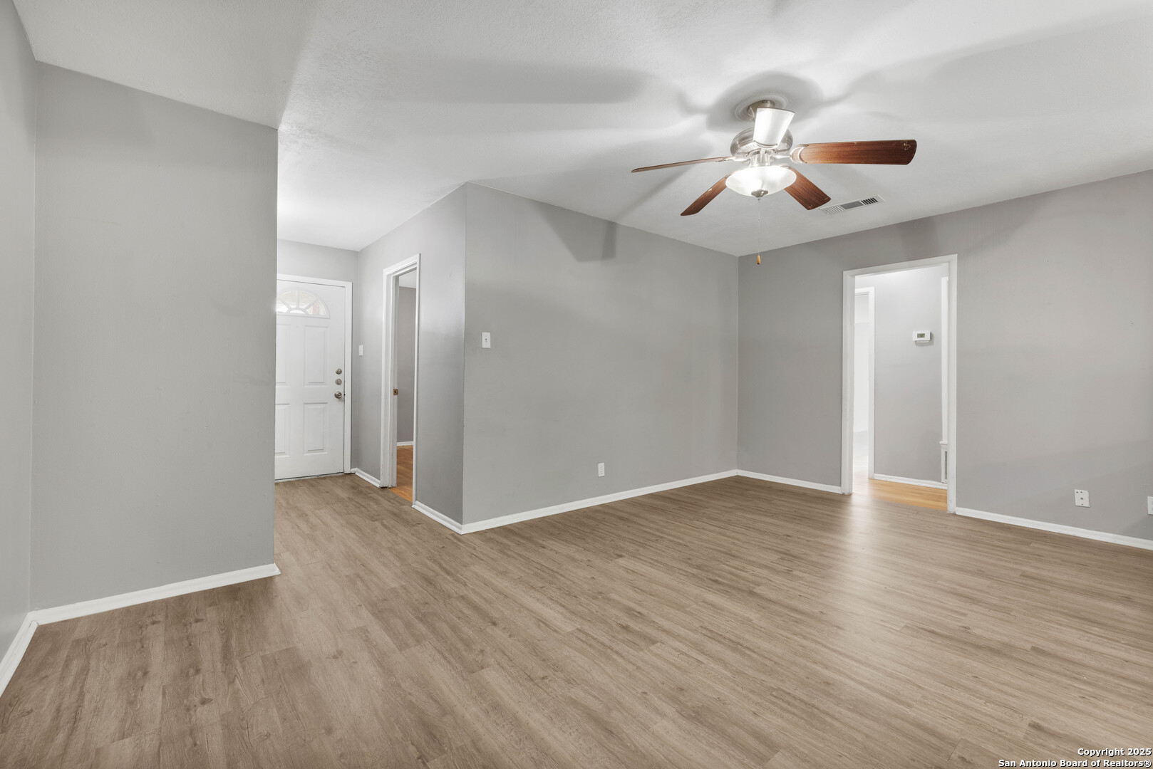 6012 Evers Road Leon Valley, TX 78238 - Photo 10 of 17 an empty room with wooden floor fan and windows