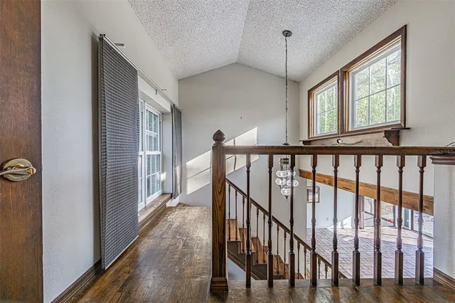 a view of hallway with wooden floor and stairs